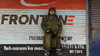 An Indian paramilitary trooper stands guard infront of closed shops during a lockdown in Srinagar, Kashmir. AFP