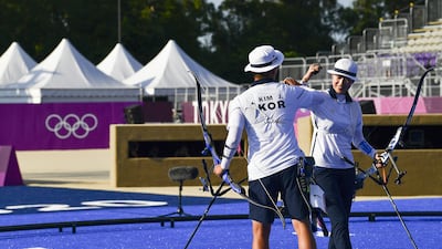 Kim Je Deok and An San of South Korea celebrate gold in the archery mixed team event.