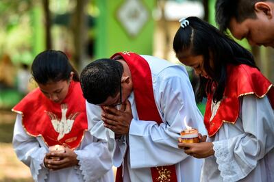 People pray to mark the 15th anniversary when an earthquake and resulting tsunami at a cemetery containing mass graves in Ulee Lheue, Banda Aceh on December 26, 2019. AFP