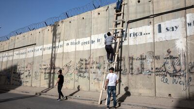 Friday mornings during Ramadan is the most crowded foot traffic time at Qalandia, as tens of thousands of Palestinians from all around the West Bank cross through to pray in Jerusalem. Meanwhile, young men who can't easily get permits into Israel scoured the wall for places to climb over risking arrest . Photo by Heidi Levine for The National