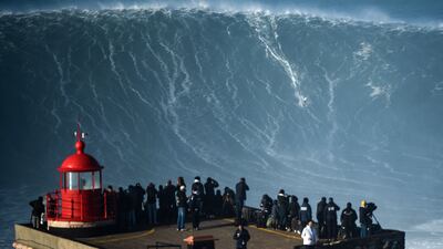 People watch a surfer during a big wave surfing session at Praia do Norte in Nazare, Portugal, on Saturday, January 8. AFP