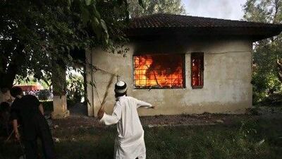 A Pakistani man throws a wooden stick at a police post during clashes that erupted as protesters tried to approach the US embassy in Islamabad.