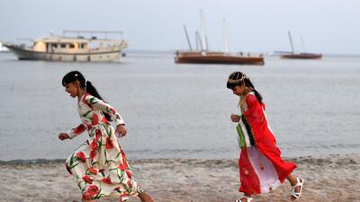 Emirati girls run on the shore on Dalma Island.
