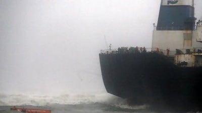 Sailors try to cling to their up-turned lifeboat, left, after it capsized while they were escaping from the Indian ship Pratibha Cauvery, which ran aground on the Bay of Bengal coastline off Chennai yesterday.