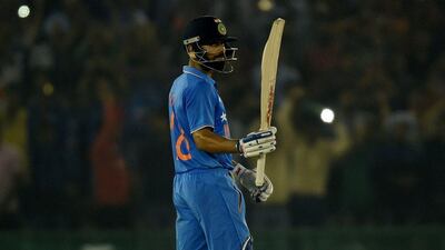 India's Virat Kohli raises his bat after completing a century against New Zealand on Sunday in Mohali. Money Sharma / AFP / October 23, 2016