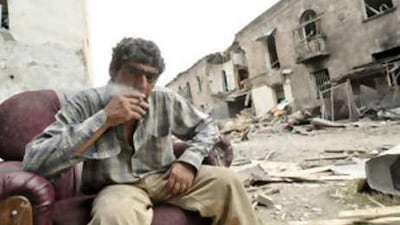 A Georgian man sits in an abandoned chair beside his destroyed apartment building in the city of Gori yesterday.
