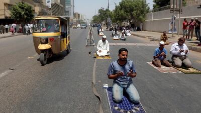 Men hold their palms together after Friday prayers along a road during the Muslim holy month of Ramadan in Karachi, Pakistan. Akhtar Soomro / Reuters