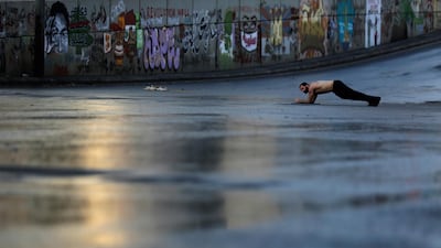 An anti-government protester exercises as protesters block the main highway that link east and west Beirut by tents, stones, and bricks during a protest against the Lebanese government in Beirut, Lebanon. AP Photo