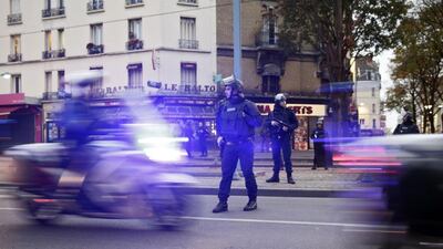 Policemen stand guard guard in the northern Paris suburb of Saint-Denis city centre, as French Police special forces raid an appartment, hunting those behind the attacks that claimed 129 lives in the French capital five days ago. Kenzo Tribouillard / AFP