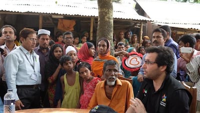 Tariq Al Gurg, chief executive of Dubai Cares, sits beside Sufia’s husband while speaking to members of the local community. Dubai Cares is building a school in Bangladesh in memory of a nanny who died saving four Emirati children. Courtesy Ogilvy
