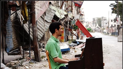 The famous image of Aeham Ahmad playing a piano amid the destruction of war in 2014 was taken by Niraz Saied. The photographer was arrested by the Syrian Army and died in jail last year. Courtesy Niraz Saied