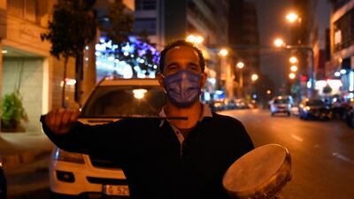 A Lebanese drummer wears a protective mask and carries a small drum as he makes his rounds waking Muslims for Suhor, the meal taken during Ramadan before sunrise prayers, amid a lockdown due to the ongoing coronavirus Covid-19 pandemic in Beirut. EPA