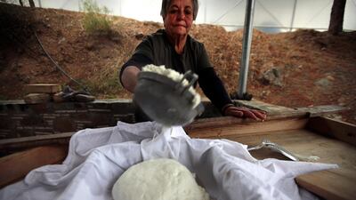 File photo, Aphrodite Philippou, 73, takes out cheese from a saucepan as she makes Cyprus' halloumi cheese at a farm in Kampia village near Nicosia, Cyprus. AP