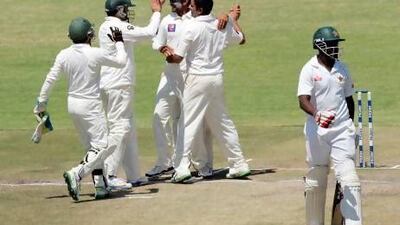 Saeed Ajmal, centre, took 11 wickets in the match, his fourth 10-plus wicket haul in Tests for Pakistan as Zimbabwe collapsed at Harare. Jekesai Njikizana / AFP