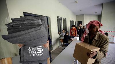 Syrian refugees receive thermal blankets and other humanitarian aid distributed by the United Nations High Commission for Refugees in preparation for winter. AFP
