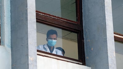 A Yemeni medic wearing a protective face mask looks out from a window of a hospital amid concerns over the coronavirus Covid-19 pandemic, in Sanaa. EPA