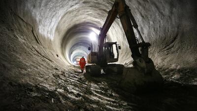 A worker walks past a digger in the partially completed Crossrail rail tunnel that will become Bond Street station. Peter Macdiarmid / Getty Images