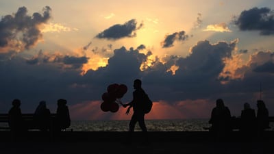 A Palestinian man sells balloons as people enjoy the sunset next to the beach of Gaza City, Gaza Strip. Mohammed Saber / EPA