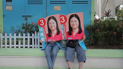 Supporters of Or Sin-yi Windy, a pro-China candidate in Hong Kong's District Council election, hold her posters. AP Photo
