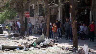 epa06061483 Local residents look at damage caused by a car bomb explosion near the al-Ghadir Square in the al-Amara neighborhood in Damascus, Syria, 02 July 2017. According to the state TV, three car bomb blasts rocked the capital Damascus on 02 July that killed at least eight people and wounded a dozen others. It said that three car bombs went off at the Airport Road and al-Amara neighborhood in Damascus city. It indicated that the authorities chased the three cars and managed to intercept two of them near the entrance of Damascus city at the airport roundabout and destroyed them, but the third car managed to arrive in the capital and the suicide bomber on board detonated it, killing a number of people and injuring others. EPA/YOUSSEF BADAWI