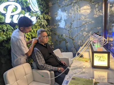 A staff member attending a customer at Oxy Pure, an oxygen bar at Select Citywalk mall in New Delhi on Saturday. Taniya Dutta for The National