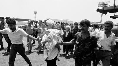 Amal militiamen and Lebanese soldiers take American passengers off a hijacked TWA Boeing 727 at Beirut airport on June 14, 1985. AFP