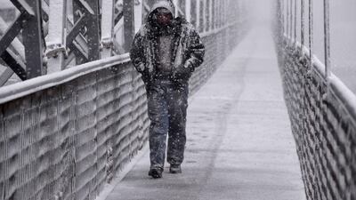 A man walks amidst a snow storm in Iraq's northern city of Mosul. AFP