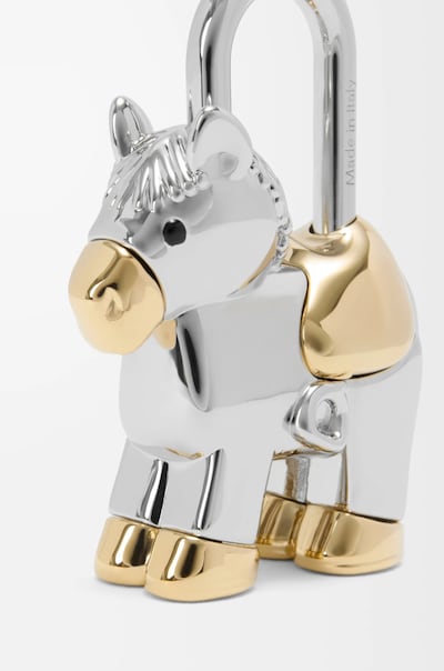 Horse-shaped padlock charm on polished metal. Photo: Loewe