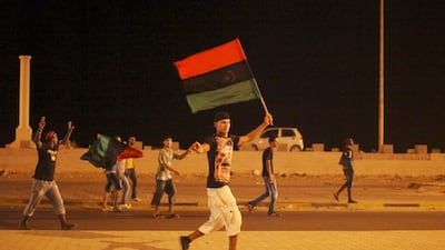 Men walk on a street carrying a pre-Gadhafi's flag during the celebrations of the capture in Tripoli of his son and one-time heir apparent, Seif al-Islam, at the rebel-held town of Benghazi, Libya, early Monday, Aug. 22, 2011. Libyan rebels raced into Tripoli in a lightning advance Sunday that met little resistance as Moammar Gadhafi's defenders melted away and his 40-year rule appeared to rapidly crumble. The euphoric fighters celebrated with residents of the capital in the city's main square, the symbolic heart of the regime. (AP Photo/Alexandre Meneghini) *** Local Caption *** Mideast Libya.JPEG-08115.jpg