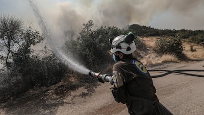 A 'White Helmet' Syria Civil Defence worker tries to extinguish the flames, during a bad year for fires in Syria. Getty