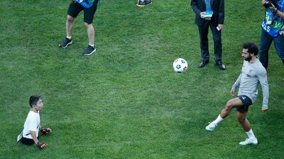 Liverpool's Mohamed Salah, plays with a child following a training session at the Besiktas Park Stadium, in Istanbul. AP Photo
