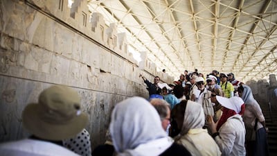 An Iranian tour guide shows the European tourists the figures carved on the wall of the eastern stairway of the Apadana palace at the ruins of Persepolis. A nuclear deal remains a hope and tour operators know optimism can vanish quickly. For the moment, local guides are filling their pockets. Behrouz Mehri / AFP