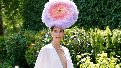 Model Katrina Renucci wears a wide-legged jumpsuit and feather hat. PA Images