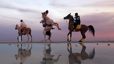 Emiratis ride horses at sunset in Abu Dhabi. AFP