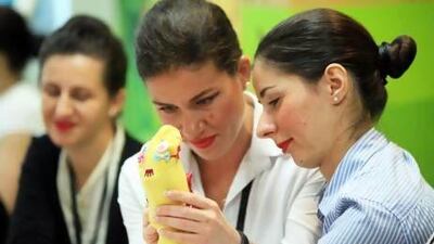 Georgiana Robu and Valeriia Danylenko create a sock puppet, the sort of activity the airline hopes will entertain the children of long-haul passengers. Photos Ravindranath K / The National