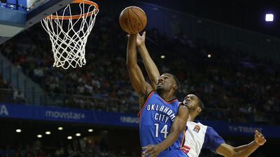 Oklahoma City Thunder guard Ronnie Price, left, jumps to dunk while being challenged by Real Madrid power forward Anthony Randolph. Daniel Ochoa de Olza / AP