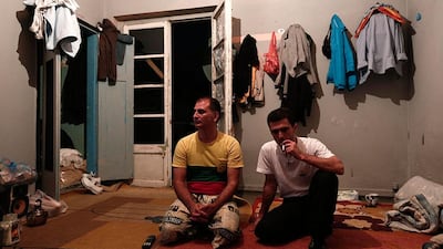 Iranian squatters sit inside a living room.