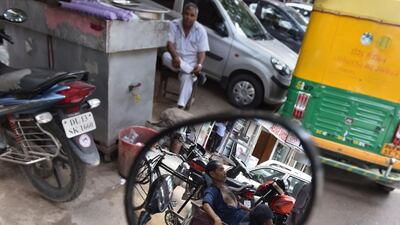 A laborer takes a nap on a tricycle at a market in New Delhi. Sajjad Hussain / AFP
