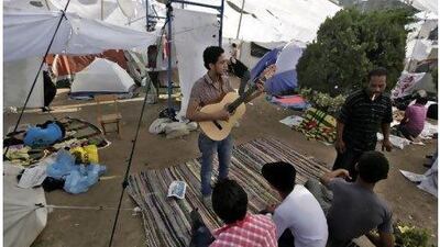 An Egyptian protester plays music during a protest in Tahrir Square, Cairo. Thousands of Egyptians have braved scorching summer heat to hold one of their biggest protests in months to demand trials for members of Hosni Mubarak's regime and express frustration with the slow pace of change. Khalil Hamra / AP Photo