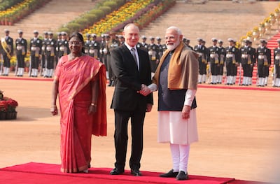 Vladimir Putin and Narendra Modi shake hands alongside Indian President Droupadi Murmu during a welcome ceremony at Rashtrapati Bhavanon, in New Delhi, on Friday. EPA