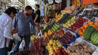 People shop at a fruit stall in the Shalaan Market in Damascus. The economy is set for a major boost with the lifting of western sanctions. AFP