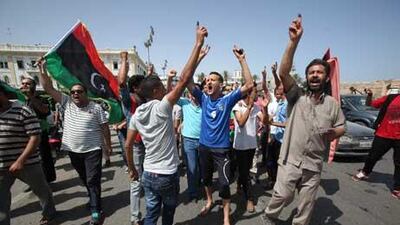 Libyans hold up their ink-marked fingers that shows they have voted as they celebrate in Martyrs' Square in Tripoli, Libya.