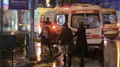 People leave as medics and security officials work at the scene after an attack at the popular Reina nightclub in Istanbul on January 1, 2017 that left at least 39 people dead and 65 injured. IHA via AP