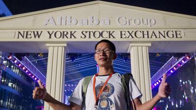 An Alibaba employee poses in front of a replica of the New York Stock Exchange during celebrations at Alibaba office in Hangzhou, China. Sherwin / EPA