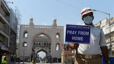 A traffic police personnel holds a placard on a deserted road in India. The coronavirus pandemic has forced many countries enforce lock downs as part of efforts to stem the outbreak AFP