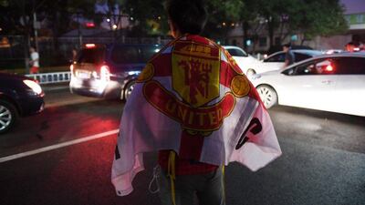 A Manchester United fan waits for the team bus after a training session a day before the 2016 International Champions Cup football match between Manchester City and Manchester United, in Beijing on July 24, 2016. Greg Baker / AFP