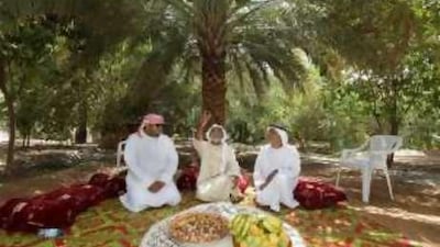 From left, Ahmed bin Mohammed Alneyadi, Ali bin Saeed, and Mohammed bin Saif, share a meal in their backyard during the summer.