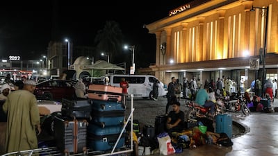 Passengers arriving from Sudan wait outside the railway station in Aswan, Egypt. PA