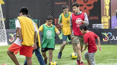Children take part in football training at the Special Olympics summer camp.