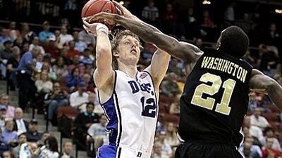 Kyle Singler of the Duke Blue Devils, in white, tries to shoot past Tavaris Washington, the Arkansas-Pine Bluff guard.